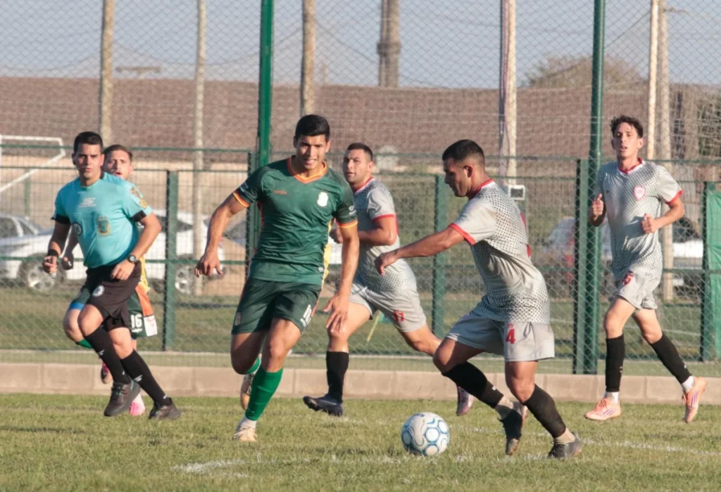 Franco Valdez maniobra ante Leandro Maciel durante el partido entre Deportivo Luján y Resistencia Central.
