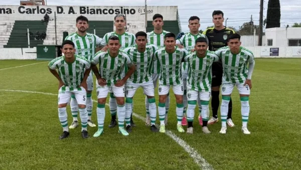 El equipo de Defensores de Vilelas posa en la cancha con su camiseta verde y blanca.