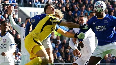 Emiliano Dibu Martínez, de amarillo, disputa una pelota aérea durante el partido ante Everton.