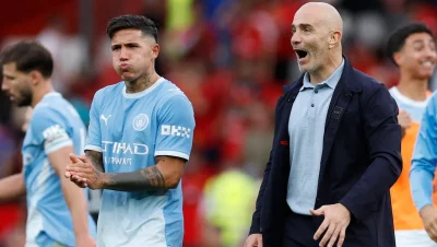 Enzo Fernández, con camiseta celeste, frente a un miembro del cuerpo técnico del Manchester City.