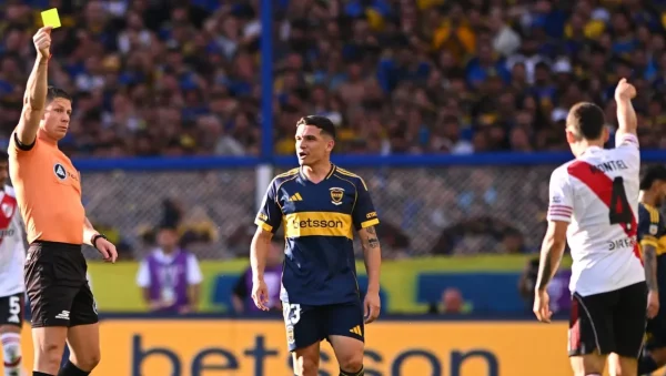 Nicolás Ramírez levanta una tarjeta amarilla durante un Superclásico entre Boca y River.